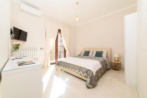 - une chambre blanche avec un lit et une fenêtre dans l'établissement HomeAway Salerno, à Salerne