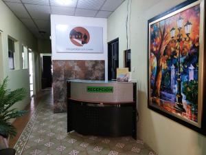a hallway with a reception desk and a painting on the wall at Hospedaje Los Lirios Chitré in Chitré
