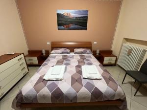 um quarto com uma cama com duas toalhas em L'AQUILA 99 HOME em LʼAquila