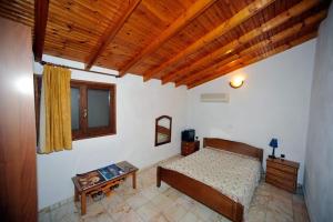 ein Schlafzimmer mit einem Bett und einer Holzdecke in der Unterkunft FOUR INDEPENDENCE HOUSES BY THE SEA in Glífa