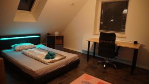 Schlafzimmer mit einem Bett, einem Schreibtisch und einem Stuhl in der Unterkunft Neubau, moderne Haushälfte in Hamburg in Hamburg