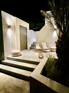 una rampa di scale che porta a un patio di notte di Saba Luxury Suites a Karterados