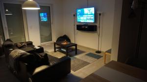 a living room with a couch and a flat screen tv at Neubau, moderne Haushälfte in Hamburg in Hamburg