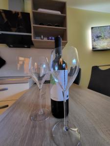 una botella de vino y dos copas de vino en una mesa en Apartma Melita, en Kobarid