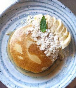 a plate with a pancake with a green leaf on it at Sandaya Luxury Suites in Naousa