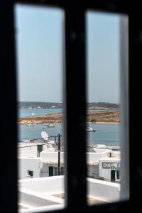 a view of a harbor through a window at Sandaya Luxury Suites in Naousa