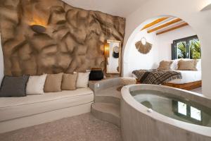 sala de estar con bañera y cama en Sandaya Luxury Suites, en Naousa