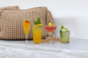 a table with three glasses of drinks on it at Sandaya Luxury Suites in Naousa