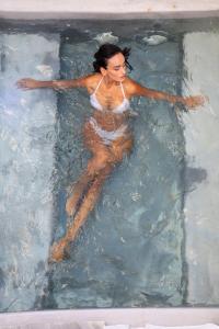 a woman is swimming in a swimming pool at Sandaya Luxury Suites in Naousa