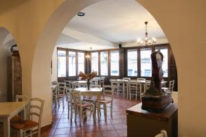 a restaurant with tables and chairs and windows at Hotel Katrca in Ljubljana