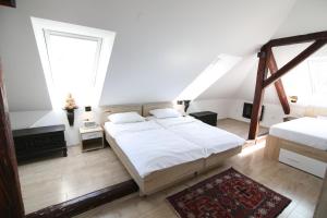 een slaapkamer met een groot bed en 2 ramen bij Hotel Katrca in Ljubljana