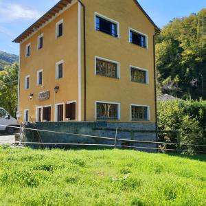 un grand bâtiment jaune avec une pelouse devant lui dans l'établissement Valles del Narcea, Apartamentos Rurales, à Cangas del Narcea