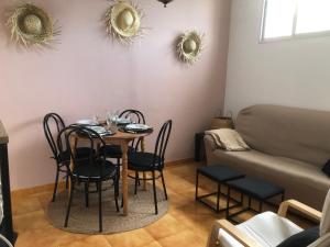 comedor con mesa, sillas y sofá en Apartamentos Océano, en Samieira