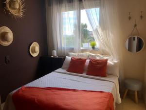Un dormitorio con una cama con almohadas rojas y una ventana en Apartamentos Océano, en Samieira