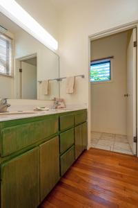 een badkamer met een wastafel en een grote spiegel bij Poipu Plantation Vacation Rentals in Koloa