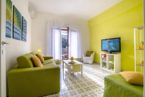 uma sala de estar com um sofá verde e uma televisão em Sunny Flat free parking em Sorrento