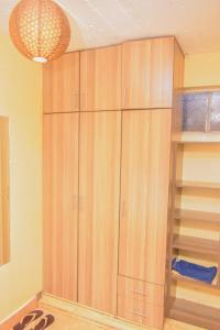 a closet with wooden cabinets and a chandelier at Leshi Place, Kinoru - Makutano, Meru in Meru
