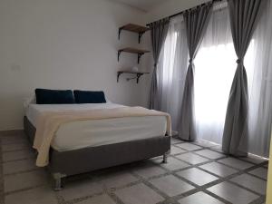 um quarto com uma cama e uma grande janela em Road Living Home em Medellín
