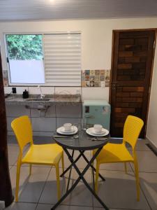 uma mesa e duas cadeiras amarelas numa cozinha em Bonito HI Hostel e Pousada em Bonito