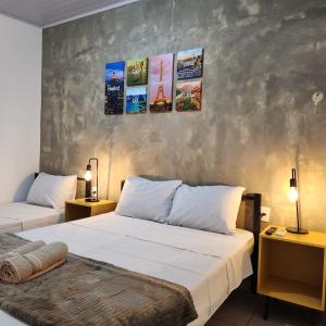 duas camas num quarto com duas lâmpadas e quadros na parede em Bonito HI Hostel e Pousada em Bonito