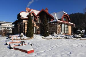 uma casa com neve no chão em frente dela em Willa Zazamcze em Muszyna