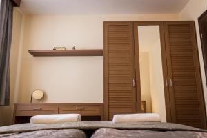 a bedroom with two beds and a closet and a mirror at Апартамент Горска приказка - Forest tale in Smolyan