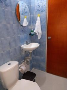 a blue tiled bathroom with a toilet and a sink at Road Living Home in Medellín