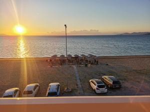a group of cars parked on the beach at sunset at House Kohili in Nea Vrasna