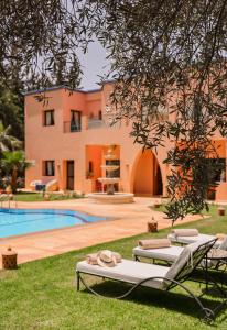 a villa with a swimming pool and a house at Tiguemine Sarah in Marrakech
