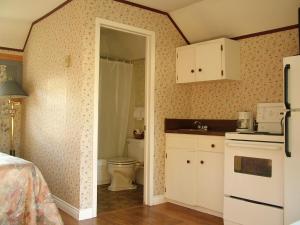 - une cuisine avec un lavabo et des toilettes dans la chambre dans l'établissement Avonlea Cottages, à Cavendish