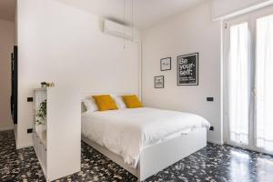 een witte slaapkamer met een wit bed met gele kussens bij Maison Teodoro in Verona