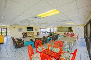 a dining room with red chairs and a table and tables and chairs at Sugar Beach Condo in Panama City Beach
