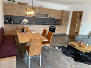 een keuken en een woonkamer met een houten tafel en stoelen bij Ferienwohnung Traumblick -Familie Seber in Mittersill