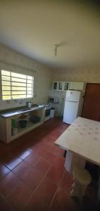 eine Küche mit einem Tisch in der Mitte eines Zimmers in der Unterkunft Casa de Temporada Próximo a Praia in Caraguatatuba