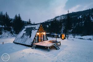 Cabaña de madera con mesa en la nieve en SouL EsCaPe, en Bălan