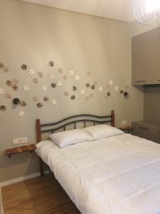 a bedroom with a bed with white sheets and flowers on the wall at Gio’s house in Tbilisi City