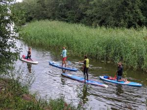 a group of people on paddle boards in the water at GaujaUpe in Gauja