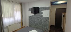 a room with a stone wall with a tv on the wall at Jaśminowe Wzgórze in Polanica-Zdrój