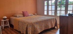 a bedroom with a bed with a blanket and a window at Maison de famille in Saint-Louis +17 photos