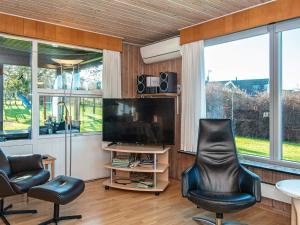 a living room with two chairs and a flat screen tv at 6 person holiday home in Glesborg in Glesborg