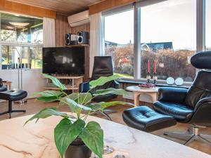 a living room with chairs and a tv and a plant at 6 person holiday home in Glesborg in Glesborg