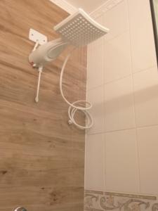 a shower with a shower head in a bathroom at Flat 206 Hotel Cavalinho Branco (3 piscinas, elevador, sauna) in Águas de Lindóia