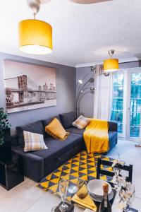 un soggiorno con divano blu e cuscini gialli di Lovely apartment easy access to London a West Thurrock