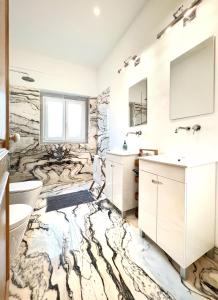 Łazienka z marmurową podłogą, umywalką i toaletą w obiekcie A Capela - A Essência de Sintra w mieście Sintra