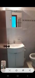 a bathroom with a sink and a mirror and a toilet at Mykonos Centro Apartamento in Carmelo
