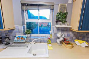 a kitchen counter with a sink and a window at Lovely apartment easy access to London in West Thurrock