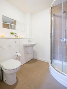 La salle de bains est pourvue de toilettes, d'un lavabo et d'une douche. dans l'établissement Inners City Apartments -On Suites, à Birmingham