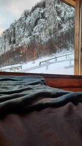 a bedroom with a view of a snow covered mountain at Cabana Himalaya Lodge cu ciubăr din inima munților Apuseni- masivul Buces -Vulcan 