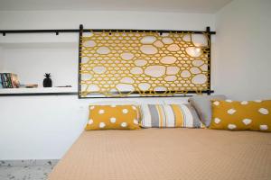 a bed with orange and white pillows on it at Cocoloco apartment in Kalymnos