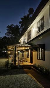 a building with chairs and a porch at night at RIO CASA , Private villa in soochipara in Meppādi